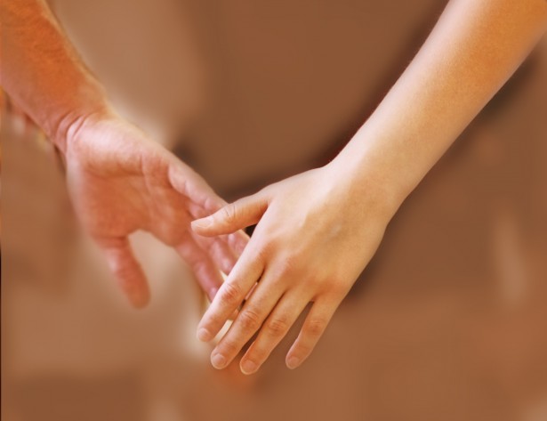 A closeup cropped shot of young people holding hands during a group therapy session